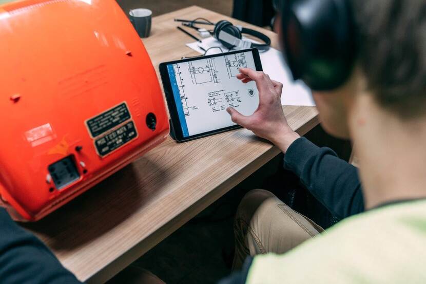 Man aan het werk met machine en tablet