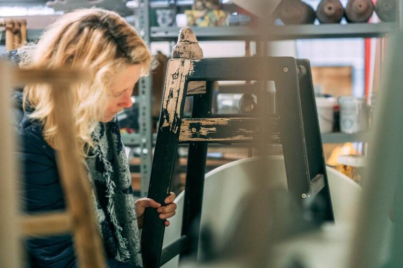 Vrouw bekijkt houten kinderstoel